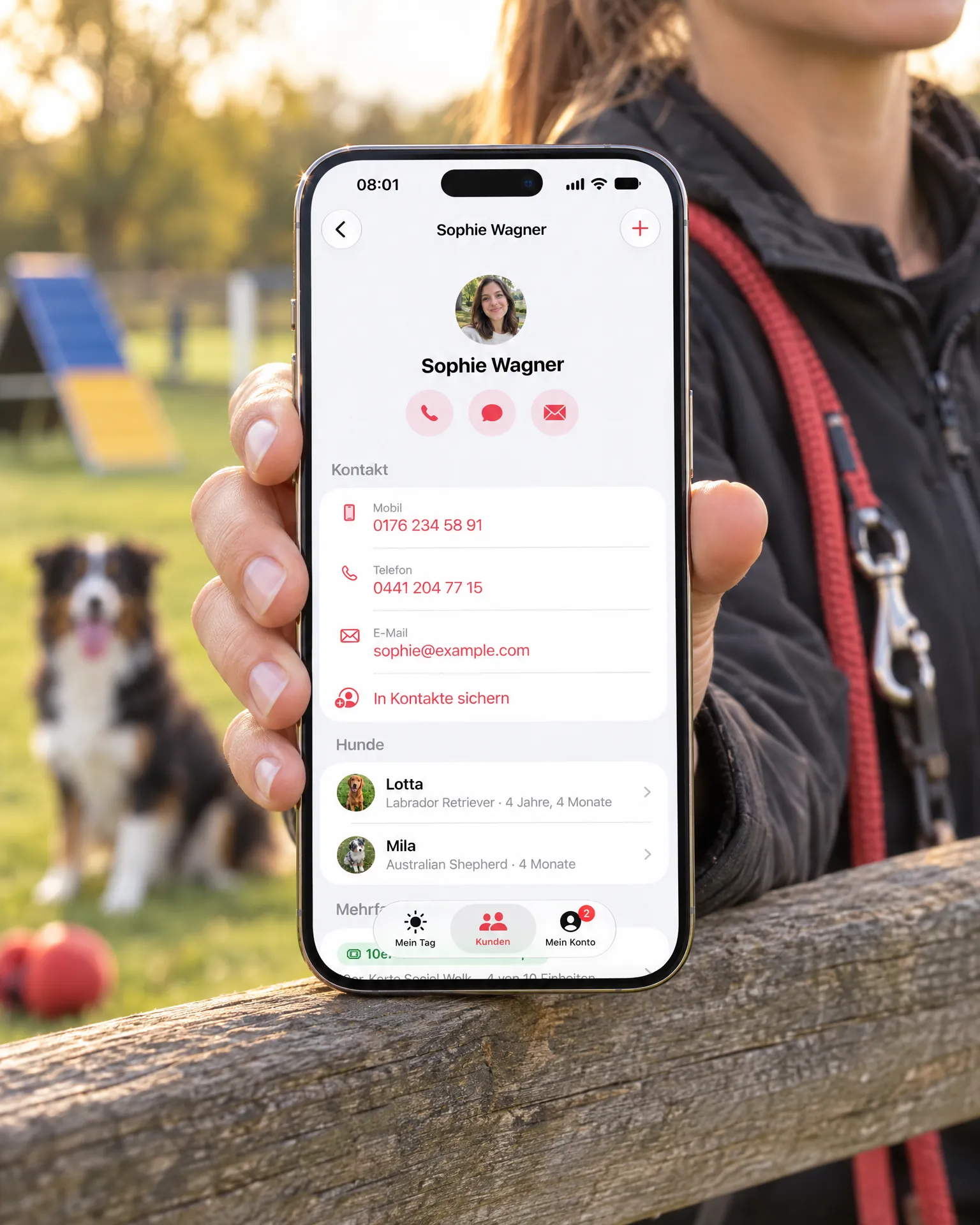 Trainerin am Zaun zeigt ein iPhone mit dem Kundenprofil von Sophie Wagner
